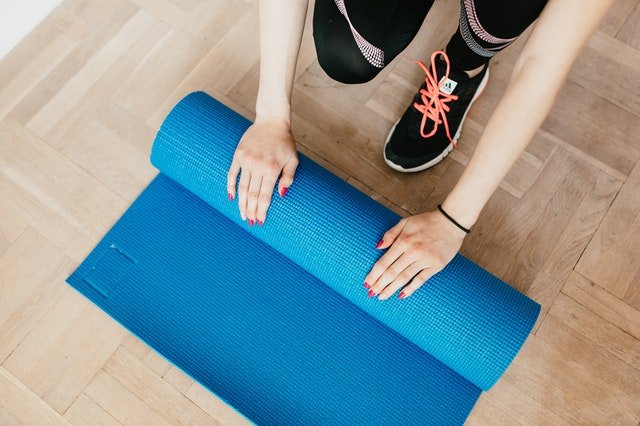 A lady using yoga mat to start her session